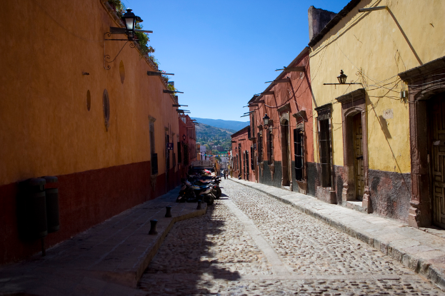 Eine leere Straße mit zahlreichen parkenden Fahrrädern, umgeben von mehreren Gebäuden, mit einem Gebäude prominent im Vordergrund.