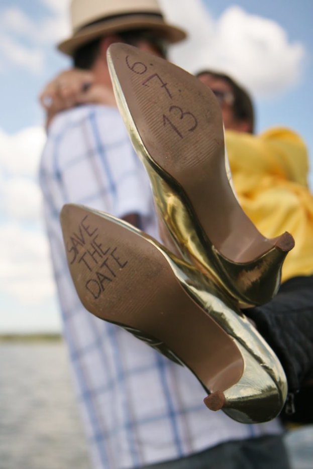 Frau in High Heels mit Aufschrift, im Hintergrund hält jemand die Beine einer anderen Frau.
