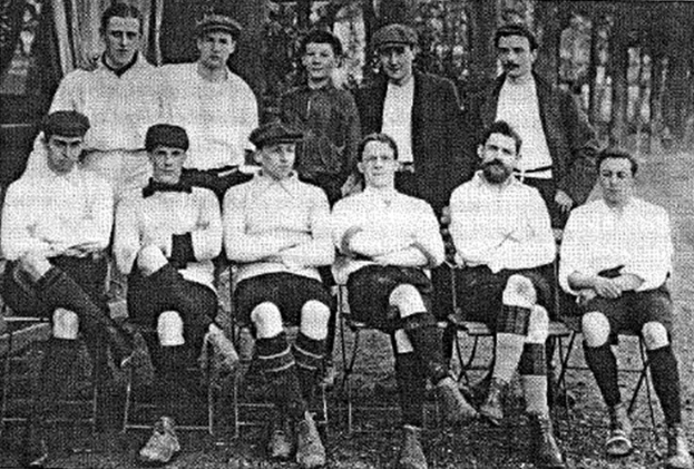 Schwarze und weiße Mannschaftsfoto des West Bromwich Albion Football Club aus dem Jahr 1918, mit sitzenden und stehenden Spielern vor Bäumen.