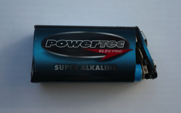 Blue Powertec Super Alkaline battery on a white surface, labeled "Powertec" in bold text.
