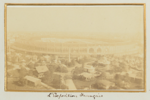 Altes Schwarz-Weiß-Foto eines Stadions umgeben von Stadtgebäuden, Bäumen und Strommasten mit Text am unteren Rand.
