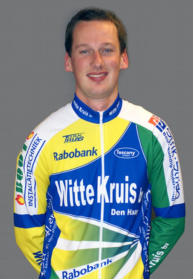 Ein Sportler posiert für ein Foto und trägt ein Hemd mit Namen mehrerer Sponsorenunternehmen.