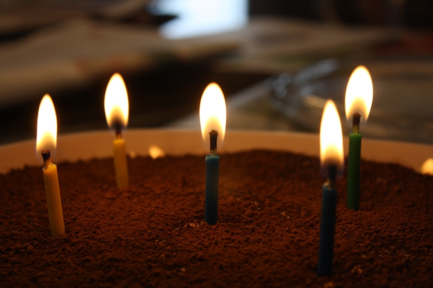 Mehrere angezündete Kerzen auf einer Oberfläche.