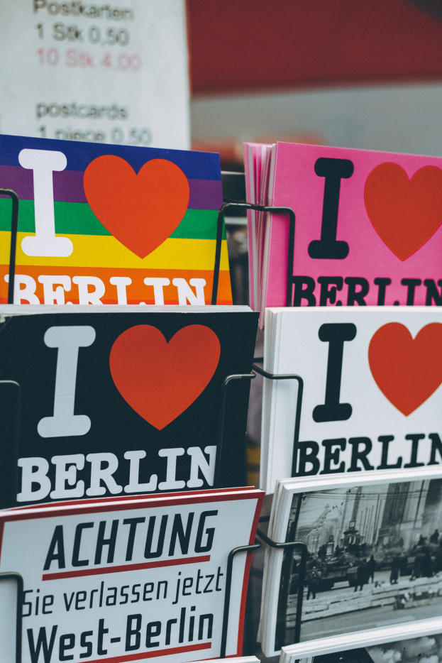 Ein Gestell mit verschiedenen Büchern und Postern mit der Aufschrift "Ich liebe Berlin" vor einem unscharfen, verträumten Hintergrund.