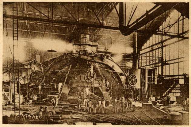 Ein Schwarz-Weiß-Foto einer Fabrikszene bei Cadillac Steel Works, das Arbeiter bei der Bedienung einer großen Maschine zeigt, umgeben von Leitern und Stäben.