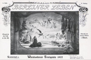 Schwarzes und weißes Foto einer Bühne von den "Wiesbadener Festspielen 1902" mit Darstellern in traditioneller deutscher Tracht und einem applaudierenden Publikum im Hintergrund, Bühne geschmückt mit bunten Lichtern.