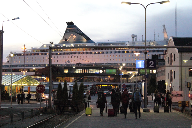 Eine volle Straße mit Menschen, die Taschen tragen und an Polen und Gebäuden vorbeigehen.