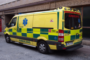 Ambulanz vor einem Backsteingebäude auf der Straße geparkt mit einem Feuerlöscher auf der linken Seite.