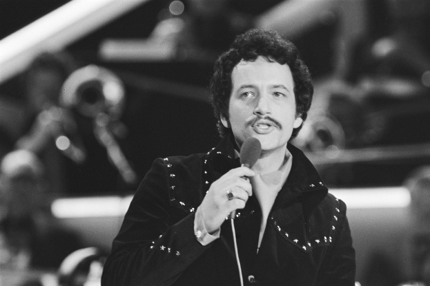 Schwarzes und weißes Foto von Elvis Presley, der ein Mikrofon hält