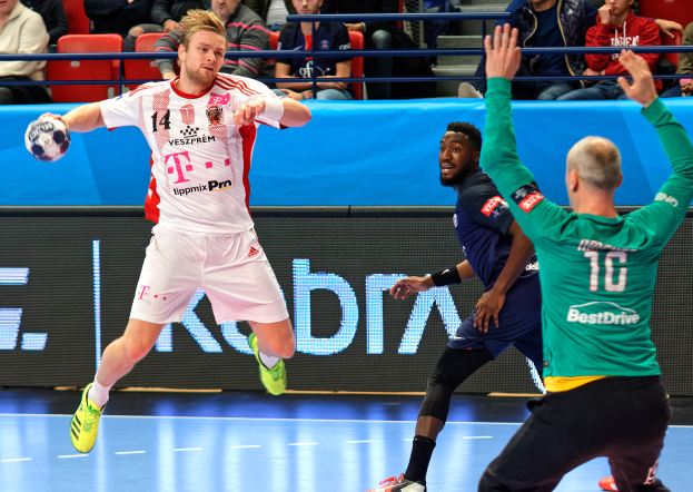 Eine Gruppe von Männern spielt Handball auf einem Platz, mit einem Ball in der Mitte der Aktion und Zuschauern im Hintergrund, die das Spiel der Futsal-Weltmeisterschaft 2019 zwischen Bayern München und Paris Saint-Germain beobachten.