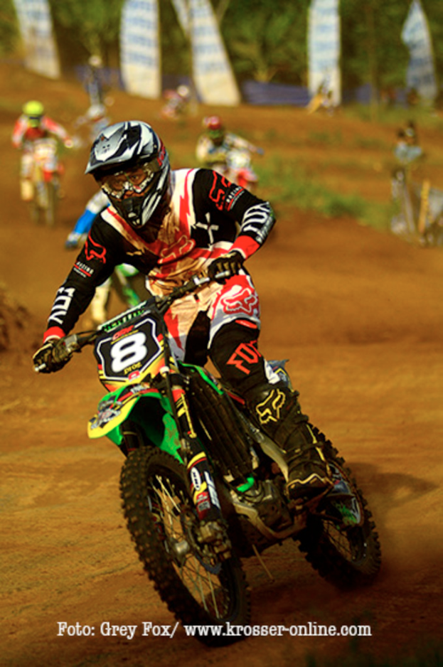 Mehrere Motorradrennfahrer mit Helmen nehmen an einem Rennen teil, mit Text am unteren Bildrand.