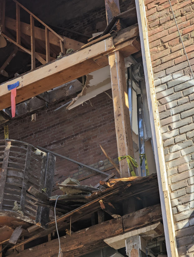 Teilweise abgerissenes Gebäude mit verstreuter Trümmer, zerbrochenen Fenstern und Türen nach Abriss.
