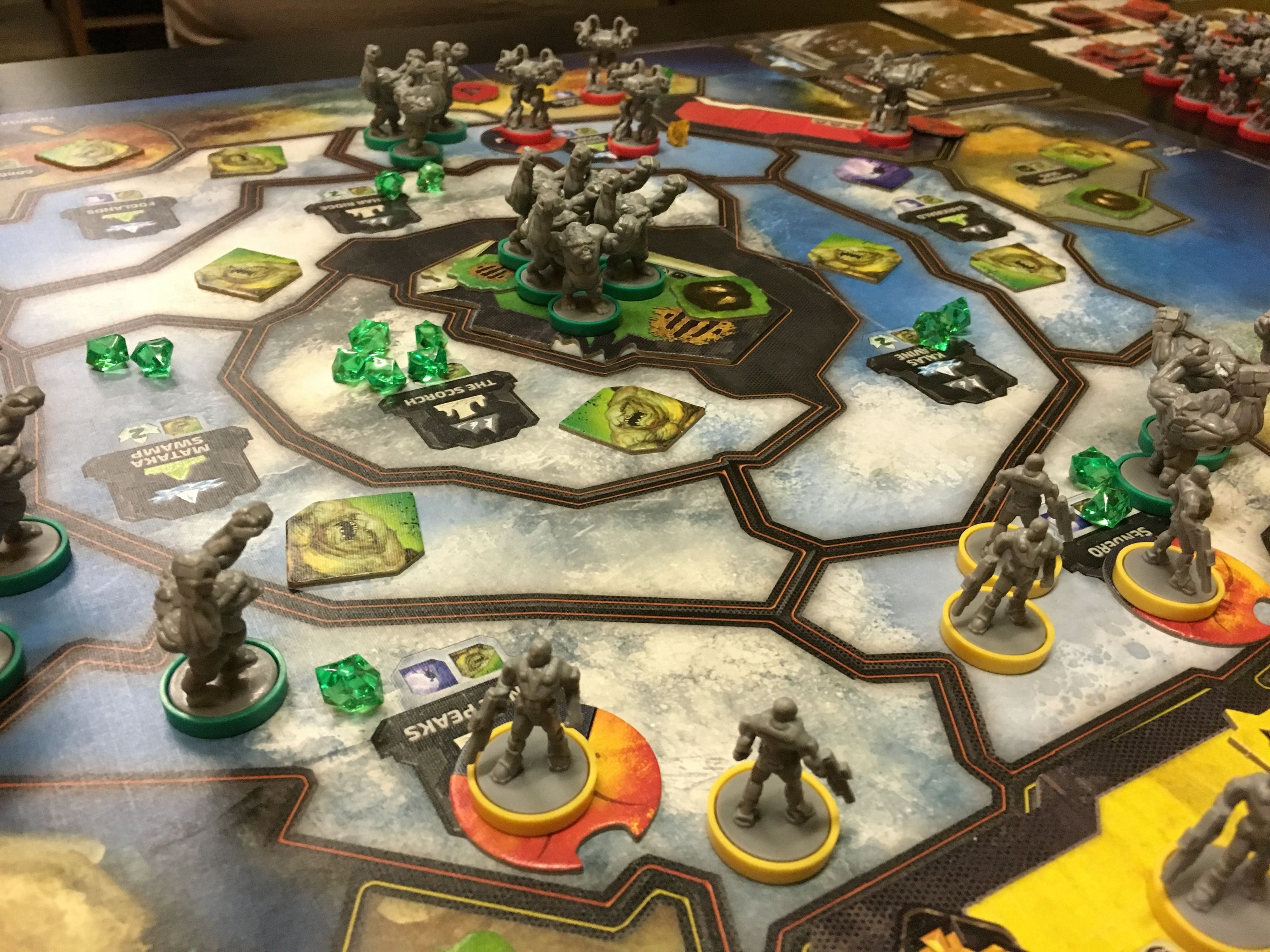 Ein Star-Wars: The-Old-Republic-Brettspiel-Szenario mit Miniaturen, die für eine Schlacht arrangiert sind, gespielt in einem Raum mit Stühlen und anderen Gegenständen im Hintergrund.