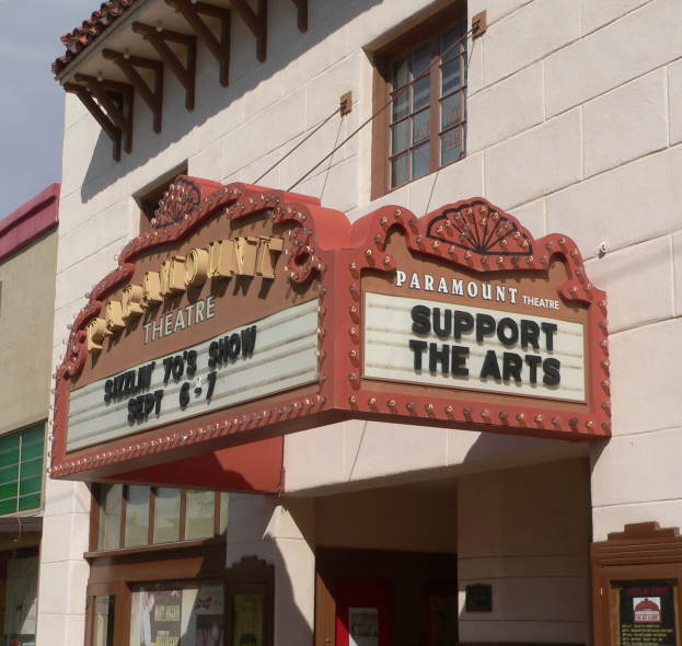 Außenansicht des Paramount Theatre in Sacramento, Kalifornien, mit Glasfenstern und -türen und einer 'Support the Arts'-Schrifttafel vor einem sichtbaren Himmel.