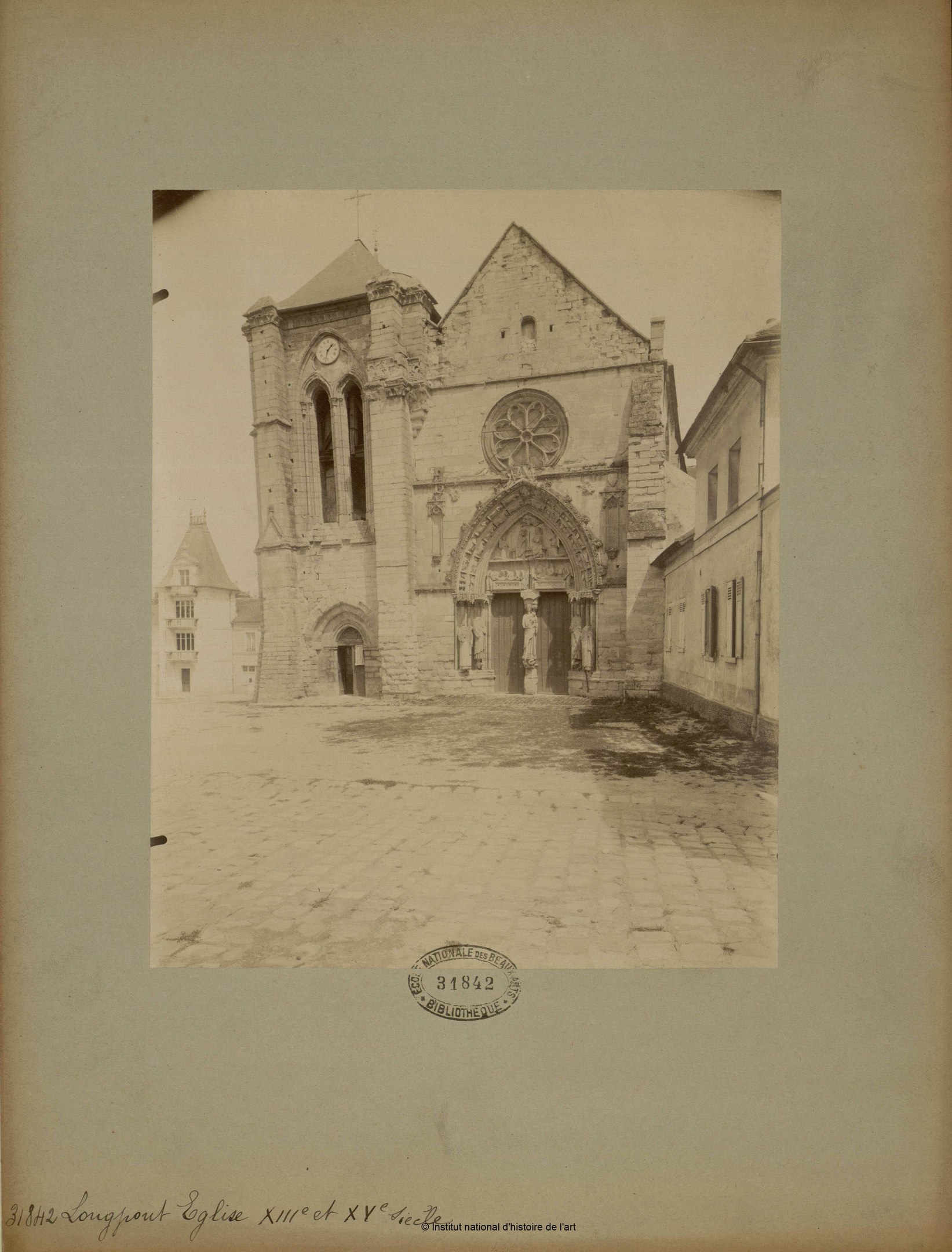 Altes Foto einer Kirche in einer städtischen Straßenszene, gerahmt und von anderen Gebäuden umgeben.
