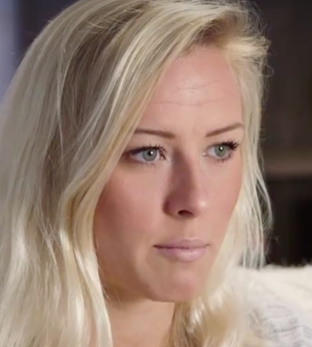 Blonde Frau mit blauen Augen im Vordergrund, die besorgt aussieht, mit einem unscharfen Hintergrund.