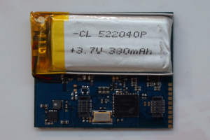 Nahaufnahme einer Handy-Batterie mit gedrucktem Text auf einer weißen Oberfläche neben einer Leiterplatte.