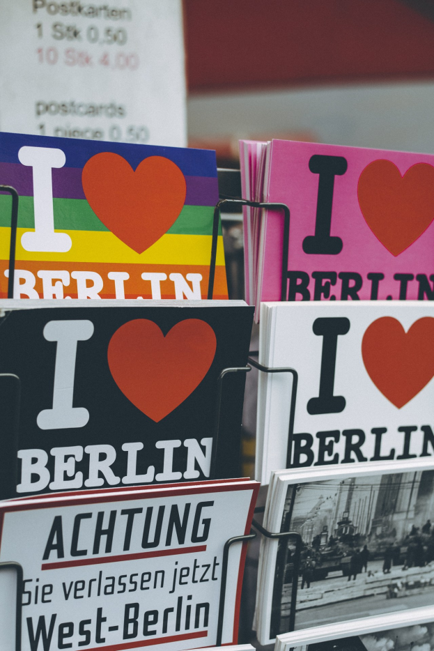 Ein Gestell mit Büchern und Postern mit der Aufschrift "Ich liebe Berlin" vor einem leicht unscharfen, traumhaften Hintergrund.