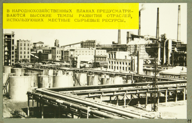 Ein Schwarz-Weiß-Foto einer Fabrik mit mehreren Gebäuden, Masten und Rohren, mit Text oben auf dem Bild.