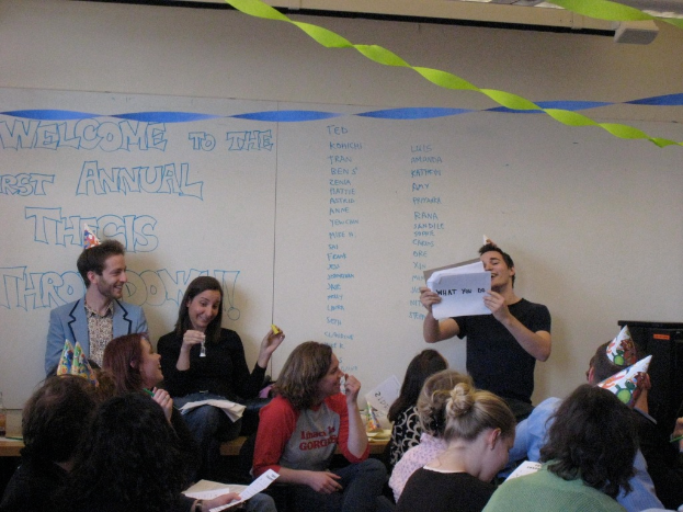 Eine Gruppe von Menschen feiert ihren ersten jährlichen Thesendown, mit Bändern auf dem Dach und einigen Personen mit Kappen.