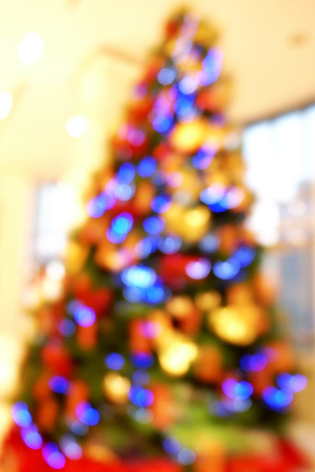 Ein unscharfer Bild eines drinnen geschmückten Weihnachtsbaums.
