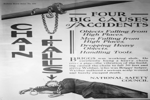 Ein schwarzes und weißes Plakat mit einer Person auf einem Pfahl liegend und Ketten daran befestigt, mit dem Text "Vier große Unfallursachen".