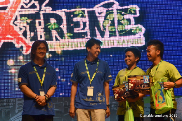 Eine Gruppe von Menschen, die jeweils eine ID-Karte tragen, mit einem Plakat im Hintergrund.