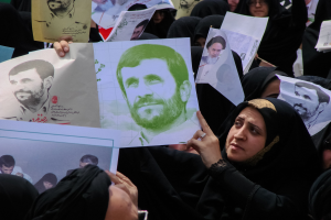 Eine Gruppe iranischer Frauen in schwarzer Kleidung, einige mit Brille, halten Bilder des Präsidenten Mahmoud Ahmadinejad während einer Demonstration in Tehran hoch.