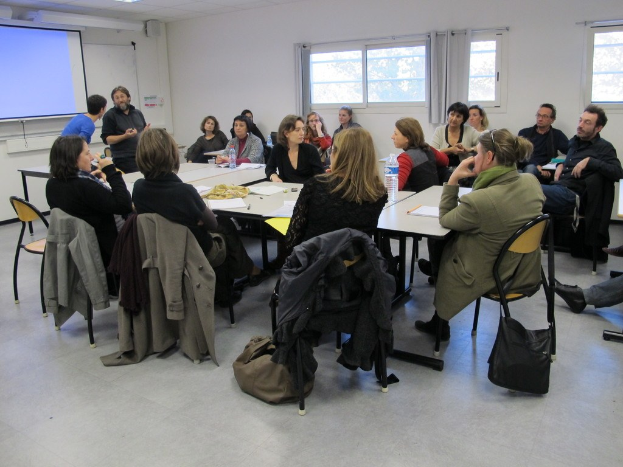 Eine Gruppe von Menschen, die sich unterhalten, wobei zwei andere separat stehen und sprechen.